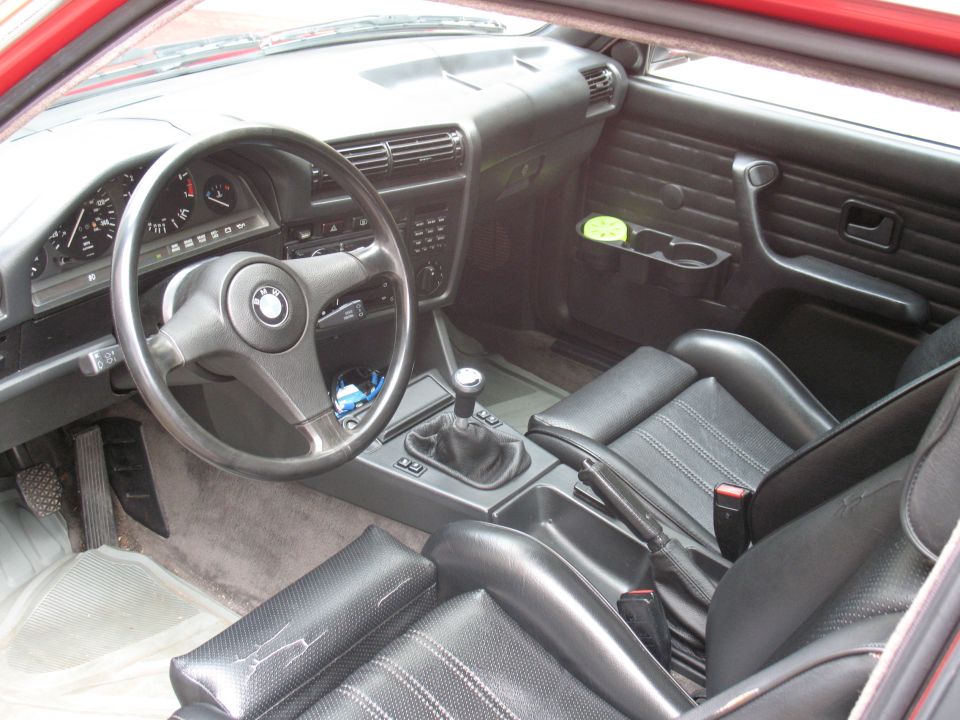 Interior of a 1986 BMW 3 Series showing dashboard, steering wheel, and seats