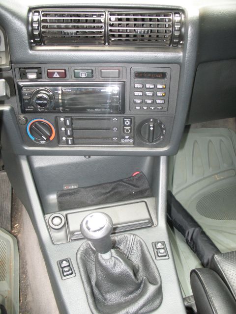 1986 BMW 3 Series - The interior of a 1986 BMW 3 Series features a manual transmission and an aftermarket Kenwood stereo system.