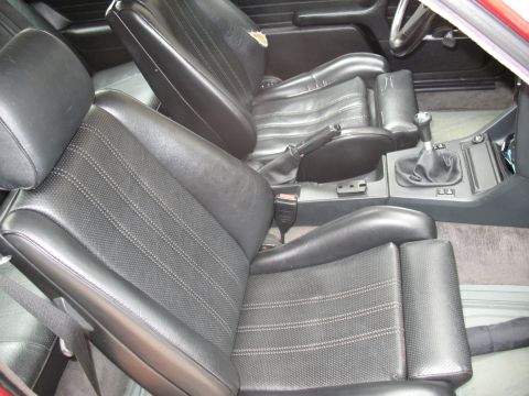 1986 BMW 3 Series - The interior of a 1986 BMW 3 Series features black cloth and leather seats with a manual transmission shifter visible.