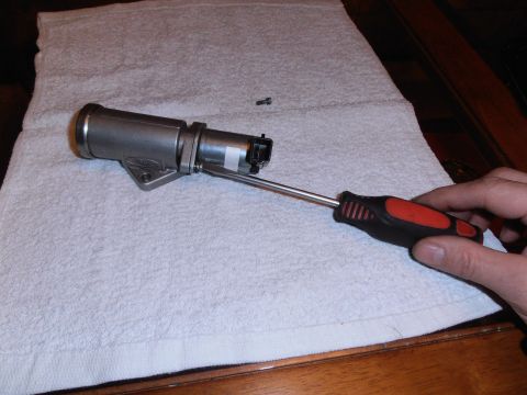 1990 Ford Bronco - Idle air control valve being worked on with a screwdriver.