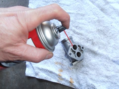 1990 Ford Bronco - Spraying lubricant on a metal engine part with multiple openings.