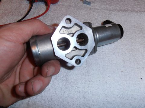 1990 Ford Bronco - Close-up of an idle air control valve, identified by a K4 marking on its metal housing.