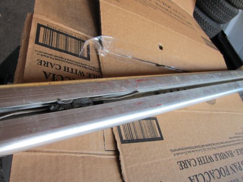 1991 Ford LTD Crown Victoria - Close-up view of damaged metal trim, possibly from a vehicle, with debris lodged within its channels.