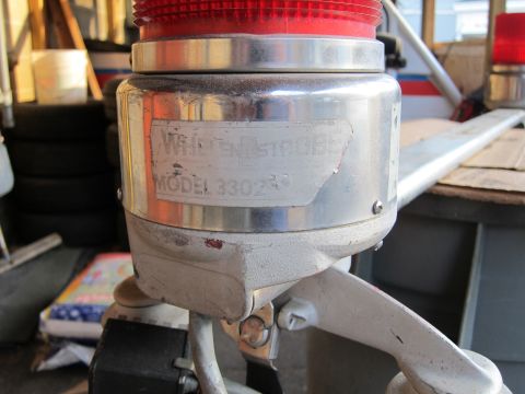 1991 Ford LTD Crown Victoria - A Whelen Strobe Model 3302 light is shown, with a red top and metallic casing.