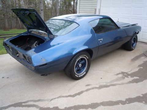 1973 Chevrolet Camaro - A blue coupe sits in a driveway with its trunk and hood open, revealing a spare tire in the trunk.