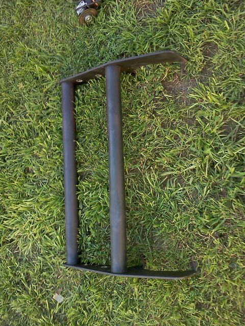 1989 Ford Bronco - A black bull bar part is shown lying on the grass.