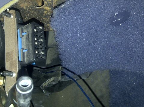 2000 Ford Crown Victoria - Close-up of a vehicle's OBD-II diagnostic port, showing wiring and interior trim.