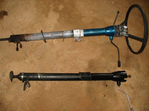 1969 Ford Bronco - Two steering columns are displayed side-by-side on a floor, one with visible rust and a blue painted section.