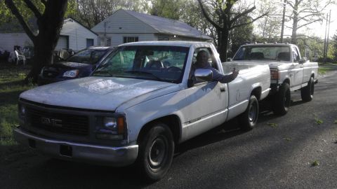 1989 Ford Bronco - A man in a white GMC pickup truck gives a thumbs up while another pickup truck follows behind him is visible.