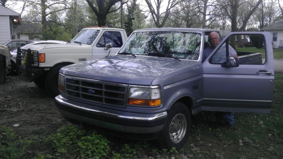 Blue 1992 Ford F-150 pickup truck, driver's door open