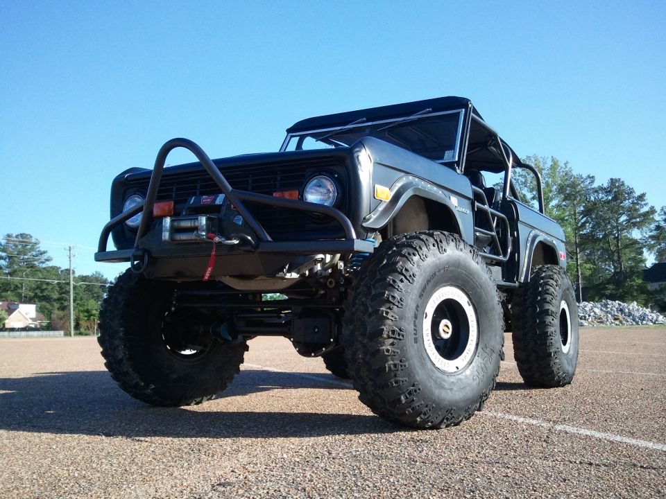 Lifted topless black early Ford Bronco on Super Swamper tires with winch bumper