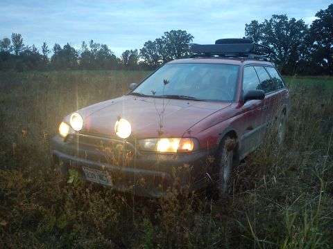 1998 Subaru Legacy - This 1998 Subaru Legacy wagon, equipped with auxiliary lights and a roof rack, is parked in a grassy field.