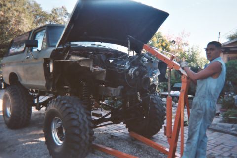 1978 Ford Bronco - A 1978 Ford Bronco is undergoing an engine swap, with the engine partially removed and supported by an engine hoist.
