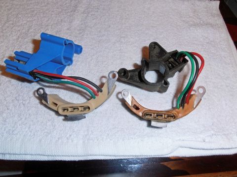 1990 Ford Bronco - Two distributor stator pickup assemblies with multicolored leads, one blue and one black, on a white towel.