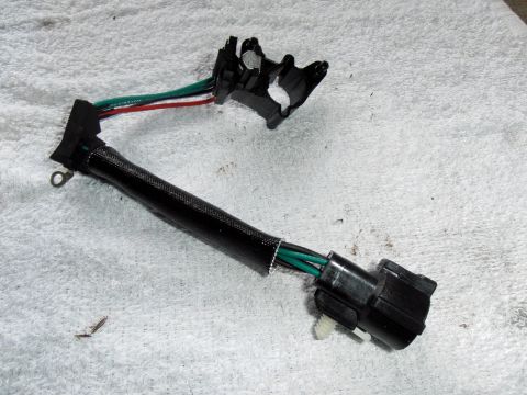 1990 Ford Bronco - A close-up view of a vehicle wiring harness, likely for a sensor, resting on a white cloth surface.