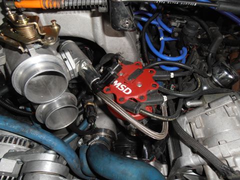 1990 Ford Bronco - Close-up view of an MSD ignition distributor and throttle body assembly within an engine bay.