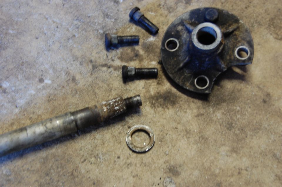 Disassembled hub and axle components on concrete floor