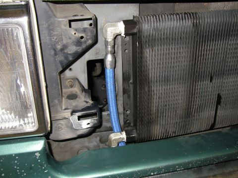 1990 Ford Bronco - Close-up of the front of a 1990 Ford Bronco, showing the radiator and headlight assembly with added transmission cooler lines.