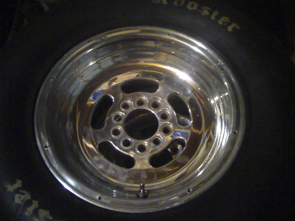 Chrome five-spoke wheel with polished finish, mounted on a tire