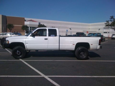 1997 Dodge 3500 - This white dually pickup truck is parked in a lot with other vehicles.