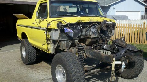 1978 Ford Bronco - Yellow 1978 Ford Bronco missing its front end, parked outdoors.