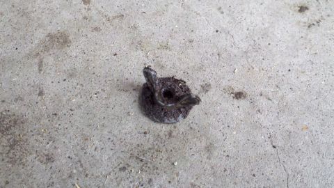 1978 Ford Bronco - A close-up view of a dirty metal fastener resting on a concrete surface.