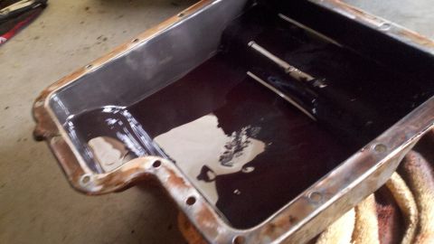1978 Ford Bronco - Transmission pan with dark fluid and sludge, possibly needing a fluid change.