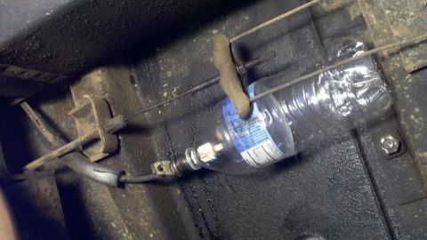 1978 Ford Bronco - A plastic bottle is used to modify the brake cable system, with a SuperMotors logo visible at the bottom right.
