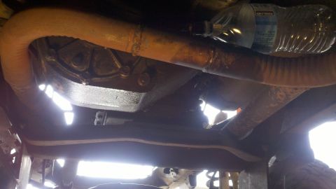 1978 Ford Bronco - A close-up view of the undercarriage of a vehicle, showing the exhaust system and transmission components.