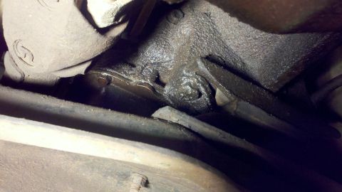 1978 Ford Bronco - Close-up of a greasy transmission housing, showing signs of oil leakage.
