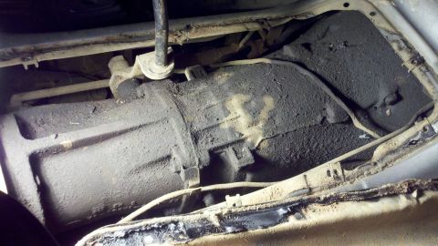 1978 Ford Bronco - Underside view of a heavily soiled transmission assembly.