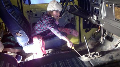 1978 Ford Bronco - Child works on the interior of a 1978 Ford Bronco, possibly during a repair or restoration.