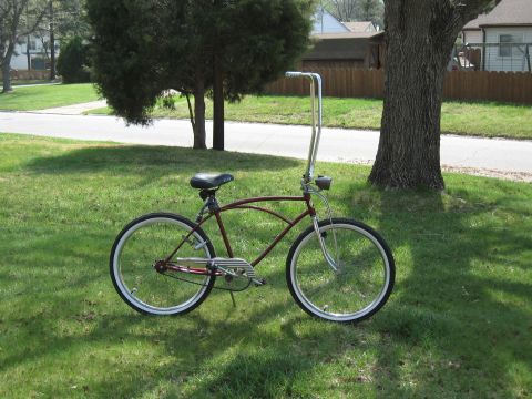 1994 Ford Bronco - A maroon cruiser bicycle with distinctive tall handlebars is shown on a grassy lawn.