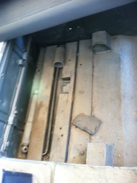 1986 Ford Bronco - The interior cargo area shows a worn floor with visible metal bracing and a pipe.