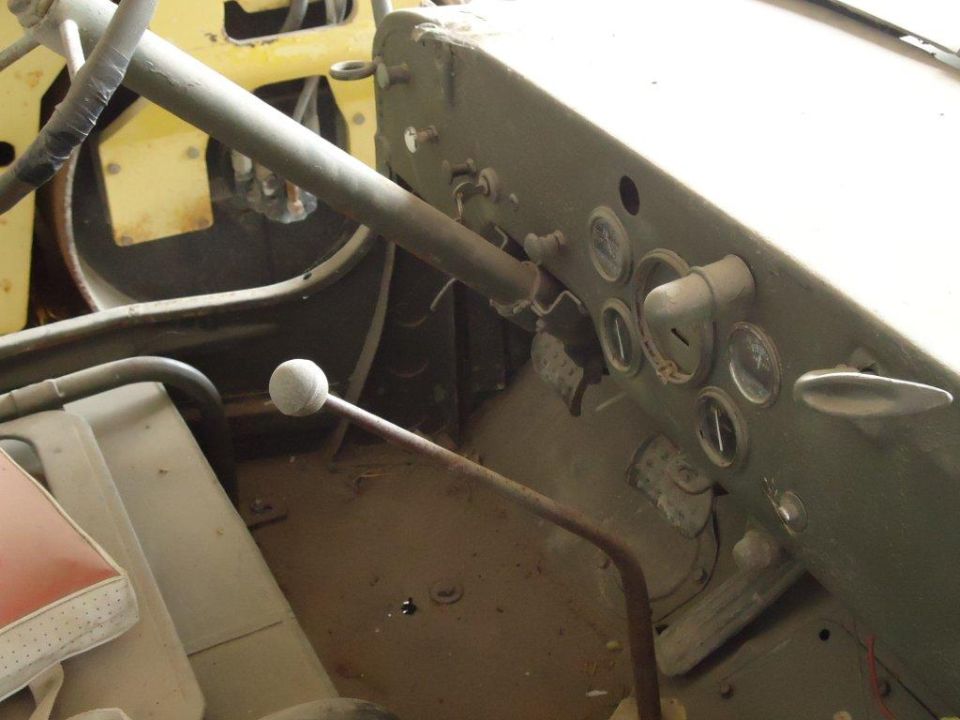 Jeep CJ interior showing dashboard with gauges, steering column, and shifter