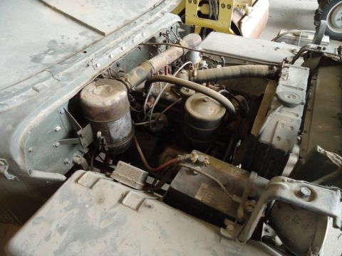 1986 Ford Bronco - The engine compartment of an older vehicle, likely a military surplus model, is shown with various components visible.