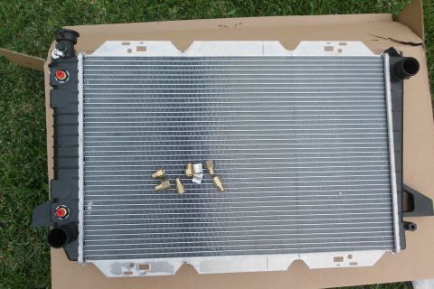 1994 Ford Bronco - Radiator with brass fittings shown on a cardboard box.
