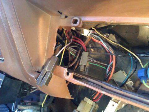 1981 Ford Bronco - Exposed wiring harness and connectors within a vehicle's dashboard area.