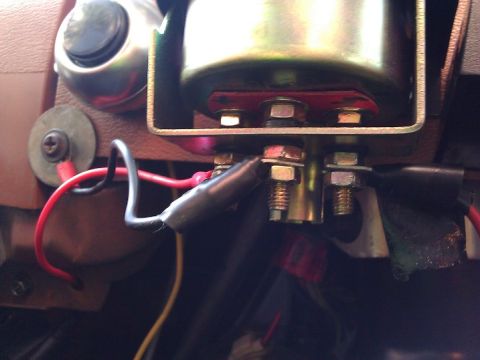 1981 Ford Bronco - Close-up view of wiring and mounting hardware for a gauge on a vehicle's dashboard.