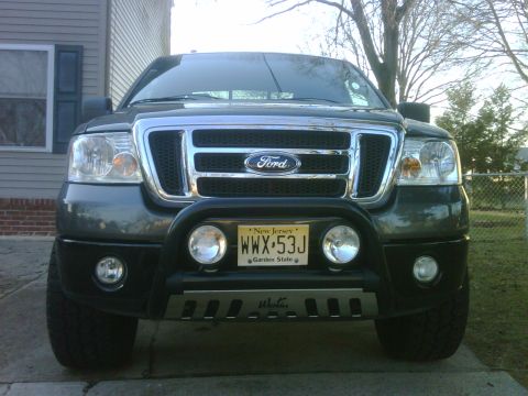 2008 Ford F-150 - Front view of a dark gray Ford F-150 pickup truck with a bull bar and auxiliary lights.