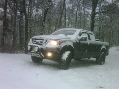 2008 Ford F-150 - A dark 2008 Ford F-150 pickup truck is seen in a snowy wooded area.