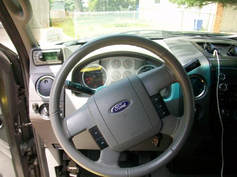 2008 Ford F-150 - The interior of a truck shows the steering wheel, dashboard, and a digital display unit.
