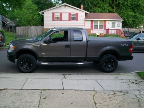 2008 Ford F-150 - This 2008 Ford F-150 pickup truck is shown from the side, aftermarket black wheels and a soft tonneau cover.