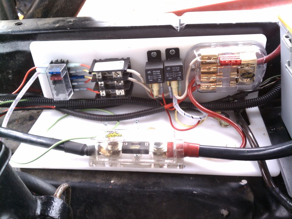 Automotive fuse box with multiple relays and fuses, wired to a large gauge cable