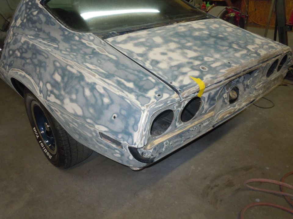 Rear of a 1973 Chevrolet Camaro with body filler and primer, showing dual taillights and exhaust cutouts