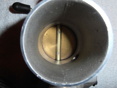 1990 Ford Bronco - Close-up of a throttle body interior, revealing the butterfly valve and part numbers.