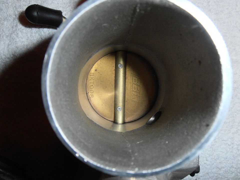 Inside view of a throttle body showing the butterfly valve and markings BKTO08 and BBK