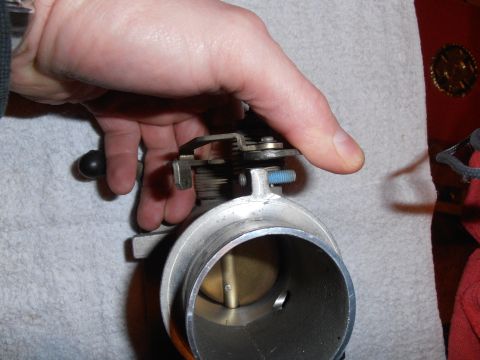 1990 Ford Bronco - Close-up of a hand manipulating a throttle body assembly, likely for maintenance or repair.