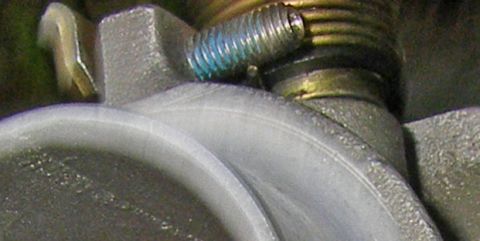 1990 Ford Bronco - A screw with blue thread locker is visible on a metal component, likely part of an engine.