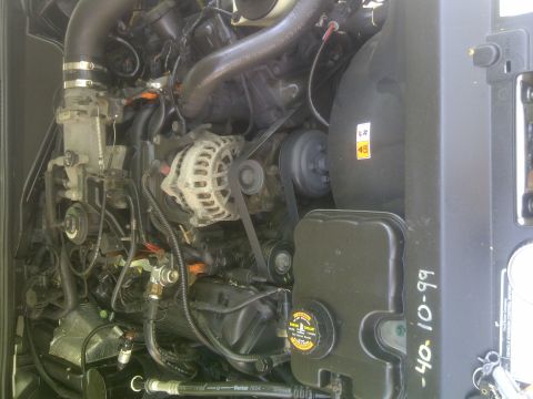 2000 Ford Crown Victoria - Close-up view of a vehicle's engine compartment, showing various mechanical components and some handwritten text.